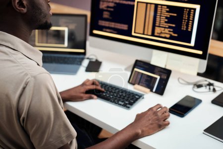 Téléchargez les photos : Ingénieur logiciel déployant des logiciels sur ordinateur et divers gadgets - en image libre de droit