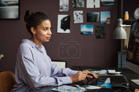 Téléchargez les photos : Créatif jeune femme édition de photos sur ordinateur pour le site Web - en image libre de droit