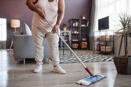 Téléchargez les photos : Femme noire nettoyer les planchers tout en nettoyant la maison, espace de copie - en image libre de droit