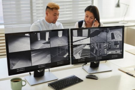 Téléchargez les photos : Image de fond de deux écrans d'ordinateur avec plusieurs flux de caméras de surveillance dans le bureau de surveillance et de sécurité - en image libre de droit