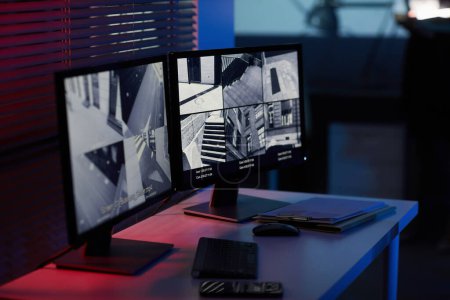 Foto de Imagen de fondo de pantallas de ordenador con imágenes de cámaras de vigilancia en habitación oscura con tonos azules y rojos - Imagen libre de derechos