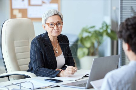 Téléchargez les photos : Portrait d'une femme d'affaires mature portant des lunettes parlant à un employé lors d'une réunion, espace de copie - en image libre de droit