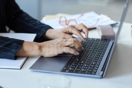 Photo for Close up of senior female hands typing at laptop keyboard while working in office, copy space - Royalty Free Image