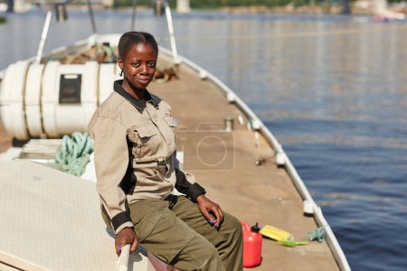 Téléchargez les photos : Portrait de jeune femme noire voilier solo et regardant la caméra en plein soleil, espace de copie - en image libre de droit