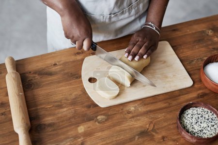 Photo for Top view of black woman baking homemade pastry on dark wood kitchen counter, copy space - Royalty Free Image