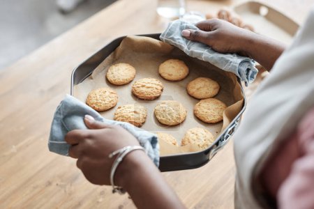 Foto de Primer plano de la bandeja de niña con galletas caseras mientras disfruta de hornear en la cocina, espacio para copiar - Imagen libre de derechos