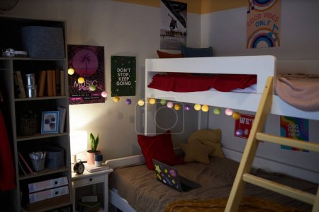 Téléchargez les photos : Image de fond de l'intérieur de la chambre des adolescents avec des affiches colorées sur le mur et un décor amusant dans un éclairage tamisé, espace de copie - en image libre de droit