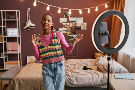 Téléchargez les photos : Portrait taille haute d'une adolescente noire enregistrant une vidéo de danse pour les médias sociaux et chantant, espace de copie - en image libre de droit