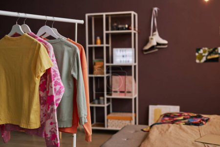 Photo for Background image of open closet and clothes on hangers in teenage girls room, copy space - Royalty Free Image