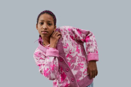 Téléchargez les photos : Portrait taille haute d'adolescente noire portant des vêtements roses à la mode posant style de mode sur fond bleu - en image libre de droit
