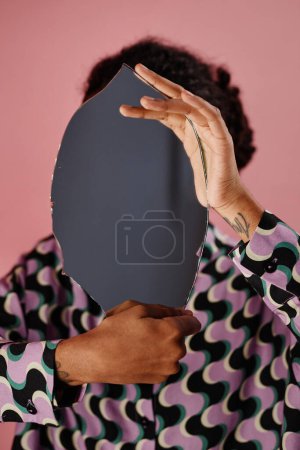 Photo for Graphic portrait of unrecognizable black woman holding mirror by face, anonymous, self reflection concept - Royalty Free Image
