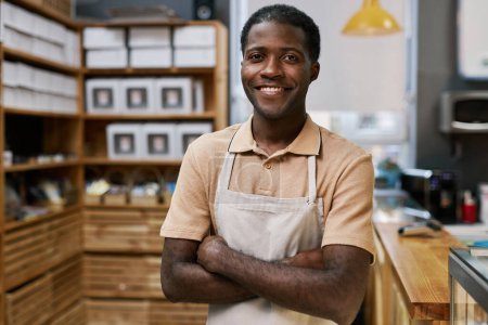 Téléchargez les photos : Portrait d'un boulanger noir positif debout les bras croisés - en image libre de droit