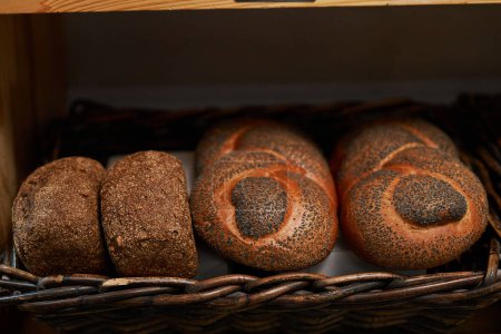 Téléchargez les photos : Pain tressé aux graines de pavot et pains sans gluten sur étagère en boulangerie - en image libre de droit