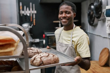 Téléchargez les photos : Portrait de plateau de cuisson positif avec pain de seigle frais - en image libre de droit
