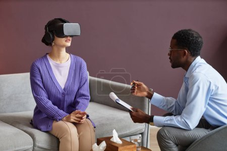 Photo for Young woman wearing virtual reality headset when having therapy session - Royalty Free Image