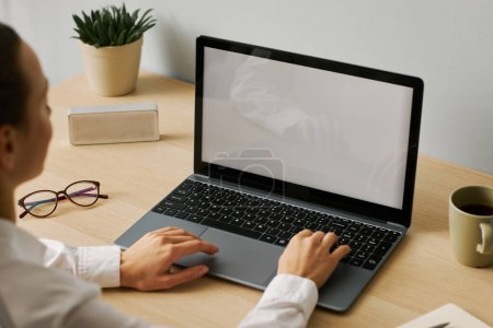 Foto de Imagen de fondo mínima de la mujer joven usando la maqueta de la pantalla blanca del ordenador portátil en el lugar de trabajo del escritorio, espacio de copia - Imagen libre de derechos