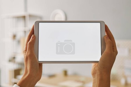 Foto de Minimalista primer plano de la mujer sosteniendo tableta digital con pantalla blanca maqueta - Imagen libre de derechos