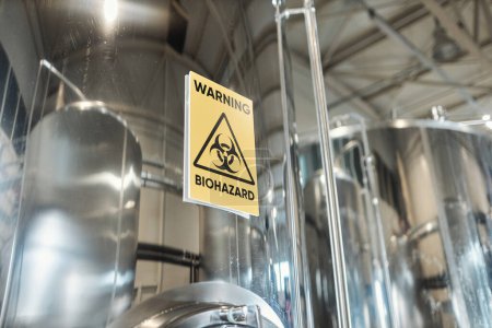 Téléchargez les photos : Image de fond du panneau d'avertissement de danger biologique sur le réservoir de stockage dans l'usine chimique, espace de copie - en image libre de droit