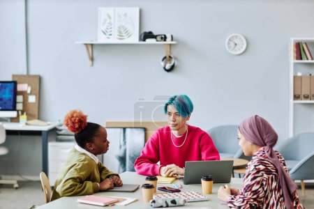 Photo for Diverse group of creative young people brainstorming project during meeting in office focus on Asian man with colored hair - Royalty Free Image