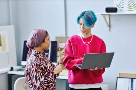 Photo for Waist up portrait of creative gen Z team discussing project while standing in office and holding laptop - Royalty Free Image