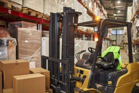 Photo for Forklift truck in warehouse interior with tall shelves, copy space - Royalty Free Image