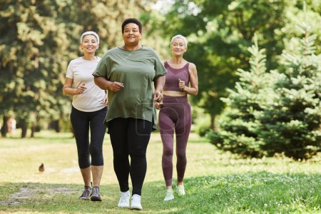 Photo for Group of active senior women running towards camera outdoors and smiling - Royalty Free Image