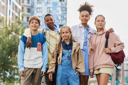 Photo for Group of five multicultural secondary school learners in casualwear standing in row in urban environment and looking at camera - Royalty Free Image
