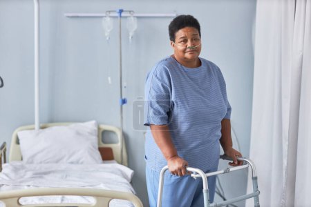 Foto de Retrato de mujer mayor negra de pie con apoyo en la habitación del hospital y mirando a la cámara, espacio para copiar - Imagen libre de derechos