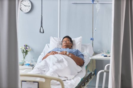 Foto de Retrato de mujer mayor durmiendo en cama en habitación de hospital con tubos y soporte IV - Imagen libre de derechos