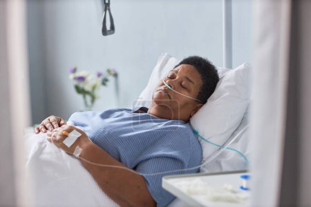 Foto de Paciente mayor que duerme en la cama en la habitación del hospital con tubos de soporte de oxígeno - Imagen libre de derechos