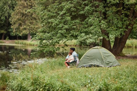 Foto de Amplia vista del ángulo en la madre y la hija acampando juntos al aire libre y la pesca, espacio de copia - Imagen libre de derechos