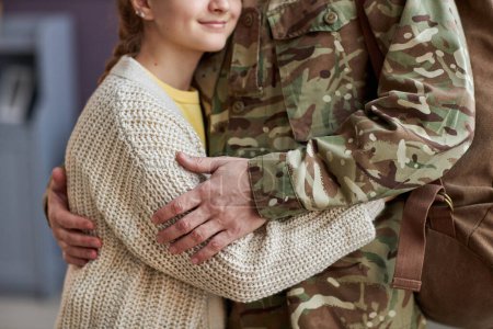 Foto de Primer plano de un hombre irreconocible con uniforme militar abrazando a la hija que regresa a casa - Imagen libre de derechos