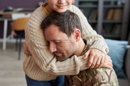 Téléchargez les photos : Portrait d'une fille embrassant un père fatigué rentrant de l'armée - en image libre de droit