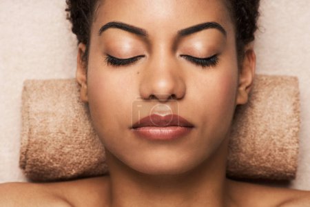 Téléchargez les photos : Visage de jeune femme relaxant dans le salon après un traitement spa - en image libre de droit
