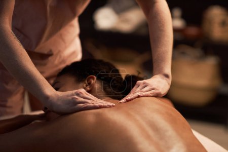 Photo for Masseuse massaging back of young woman with natural oils - Royalty Free Image