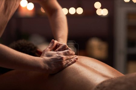 Foto de Masajista aplicando ligeros toques al masajear la espalda del cliente - Imagen libre de derechos