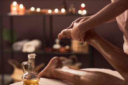 Photo for Closeup image of masseuse applying oil of feet of young woman - Royalty Free Image