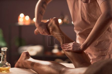 Foto de Terapeuta de spa masajea las piernas del cliente para liberar la fatiga - Imagen libre de derechos