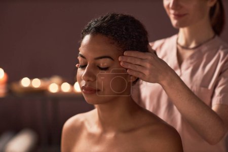 Photo for Masseuse massaging temples of client to relieve headache - Royalty Free Image