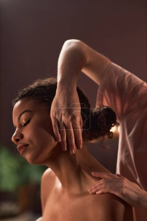 Téléchargez les photos : Masseuse massage platysma muscle de noir jeune femme - en image libre de droit