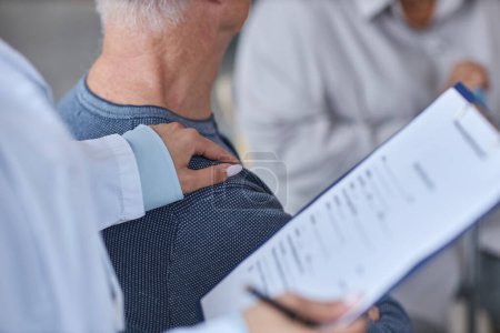 Photo for Close up of female therapist holding clipboard while working with senior patients in retirement home - Royalty Free Image
