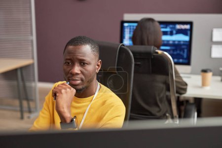 Téléchargez les photos : Portrait de l'homme noir concentré regardant l'écran d'ordinateur dans le bureau, espace de copie - en image libre de droit