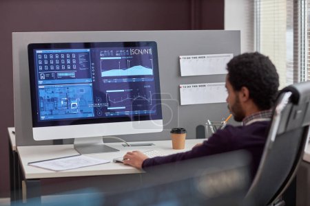 Foto de Vista posterior en el ingeniero de TI masculino que trabaja con datos en la pantalla de la computadora en el lugar de trabajo, espacio de copia - Imagen libre de derechos