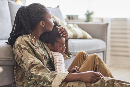 Téléchargez les photos : Jeune mère en camouflage profitant du temps passé avec sa petite fille à la maison - en image libre de droit