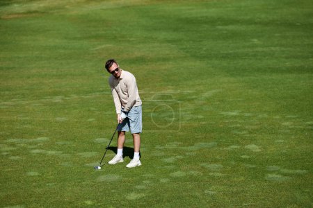Photo for High angle portrait of rich sporty man playing golf on green field in sunlight, copy space - Royalty Free Image
