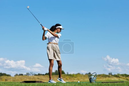 Téléchargez les photos : Portrait latéral de la femme sportive jouant au golf sur l'herbe verte à l'extérieur et club de golf oscillant, espace de copie - en image libre de droit
