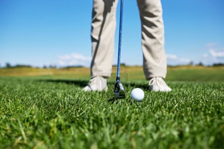 Photo for Low section of unrecognizable man playing golf on green grass, focus on ball, copy space - Royalty Free Image