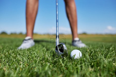 Photo for Closeup of unrecognizable person playing golf on green grass, focus on ball, copy space - Royalty Free Image