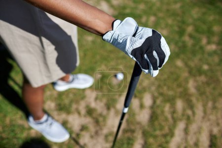 Téléchargez les photos : Vue de dessus gros plan de la main femelle gantée tenant le club de golf à l'extérieur contre l'herbe, espace de copie - en image libre de droit