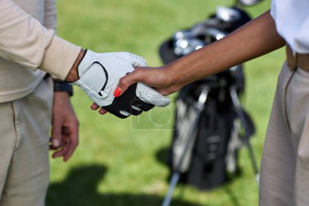 Téléchargez les photos : Gros plan de deux joueurs de golf serrant la main après le match à l'extérieur - en image libre de droit